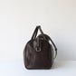 Brown leather duffel bag on a white background