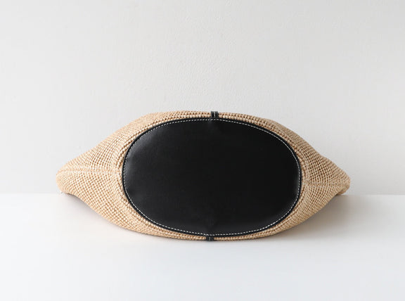 Woven clutch with black interior on a white background