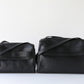Two black leather handbags on a white background