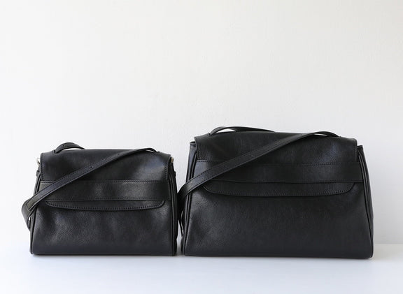 Two black leather handbags on a white background