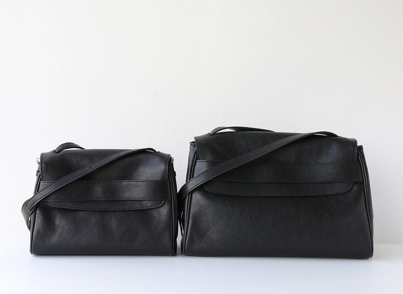 Two black leather handbags on a white background
