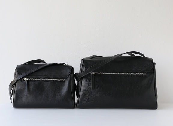Two black leather bags on a white background