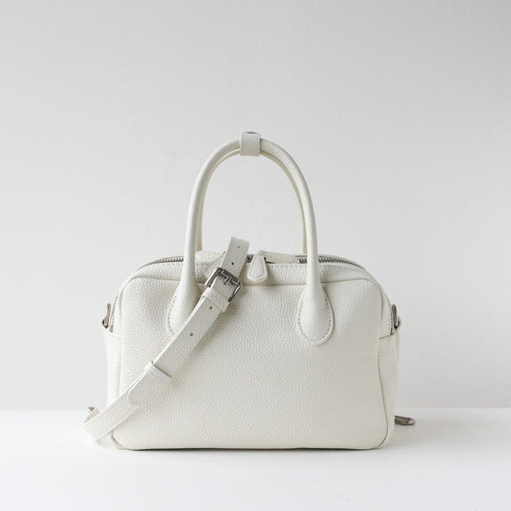 White handbag with a strap on a light gray background