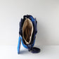 Blue handbag with beige interior on a white background