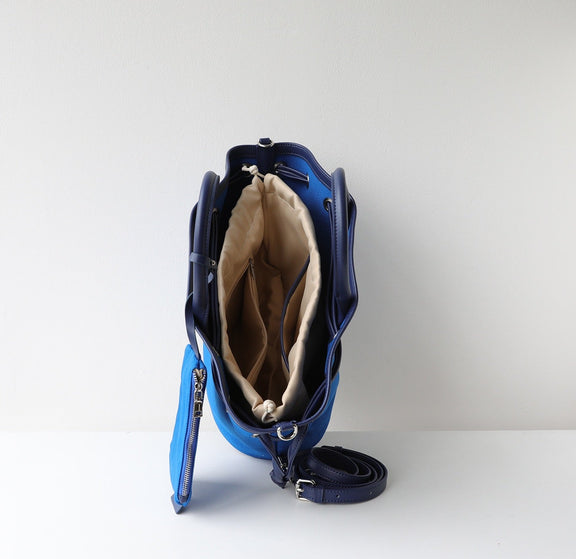 Blue handbag with beige interior on a white background