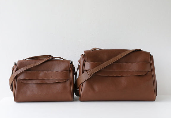 Two brown leather bags on a light gray background