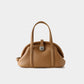 Tan leather handbag with a silver clasp on a light gray background