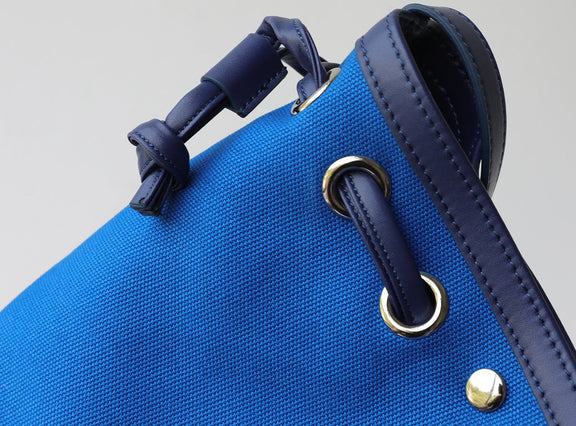 Blue bag with leather straps on a gray background