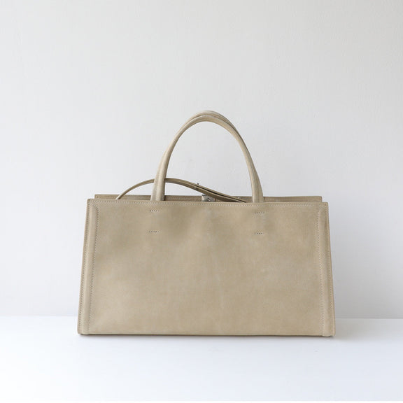 Beige leather handbag on a white background