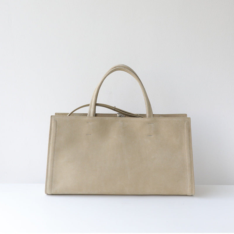 Beige leather handbag on a white background