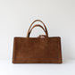 Brown leather tote bag on a white background
