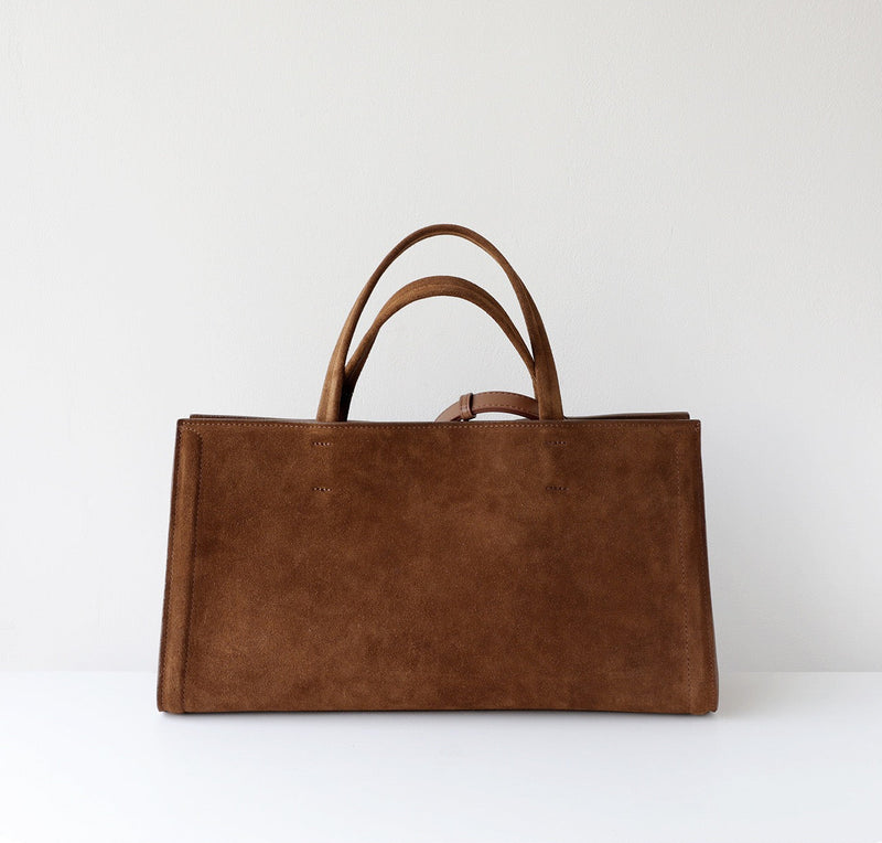 Brown leather tote bag on a white background