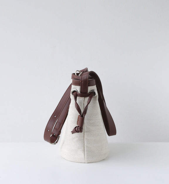 Small bag with a brown strap on a light gray background