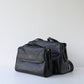 Black leather handbag on a light gray background