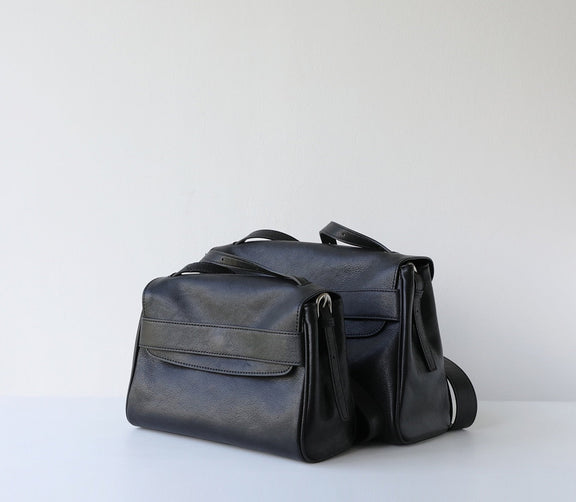 Black leather handbag on a light gray background