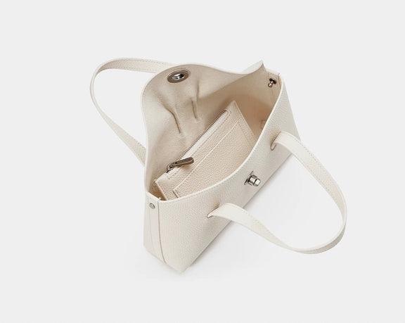 Beige handbag with a strap on a light gray background