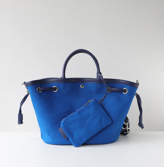 Blue handbag with matching pouch on a light gray background