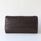 Brown leather toiletry bag on a white background