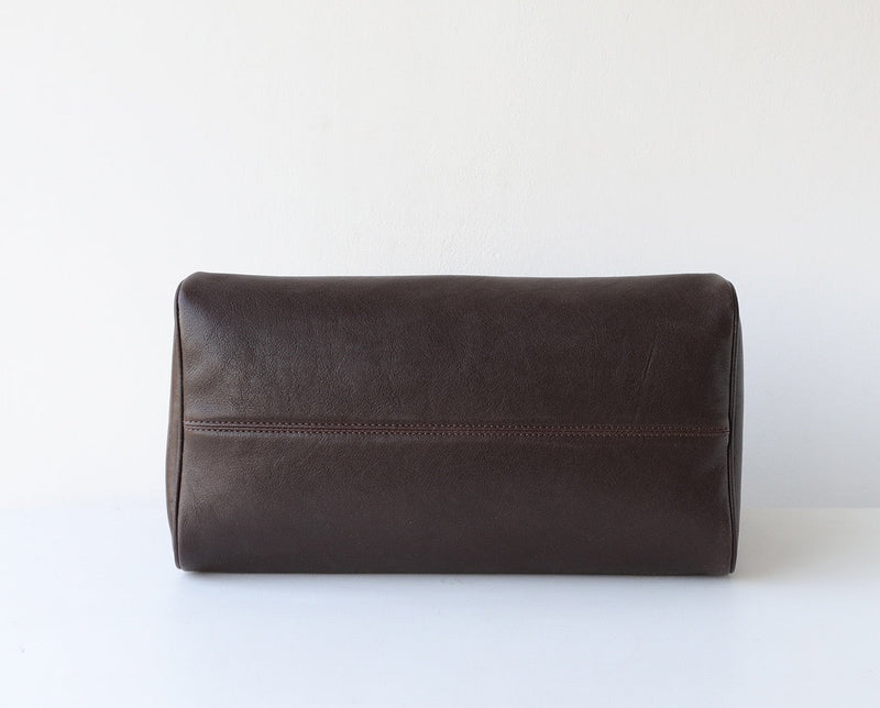 Brown leather toiletry bag on a white background