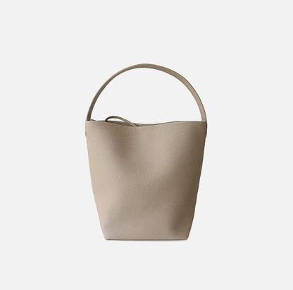 Beige handbag with a handle on a light gray background