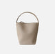 Beige handbag with a handle on a light gray background
